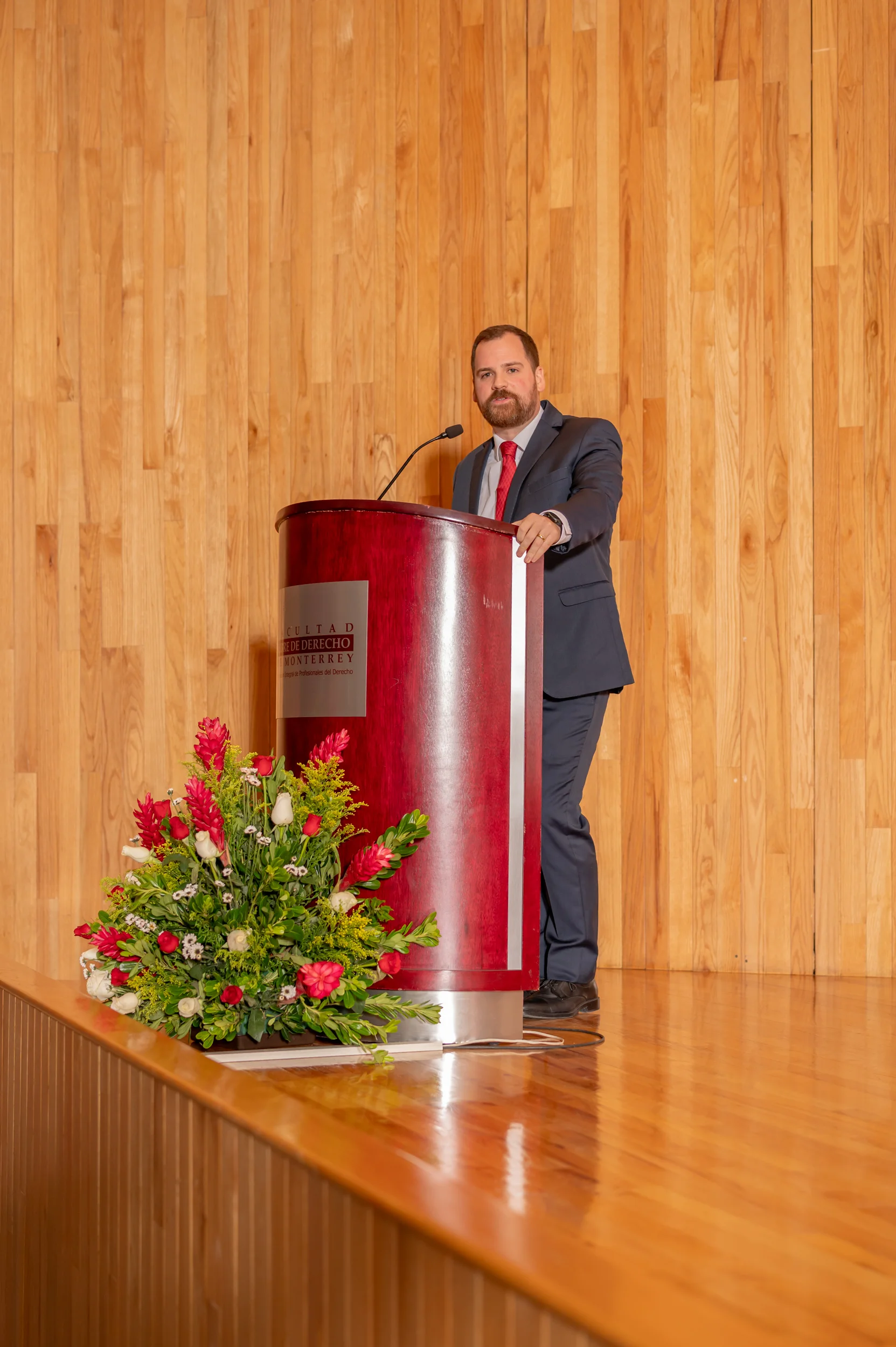 Egresado dirige un mensaje durante una ceremonia en el auditorio de la Facultad Libre de Derecho de Monterrey.
