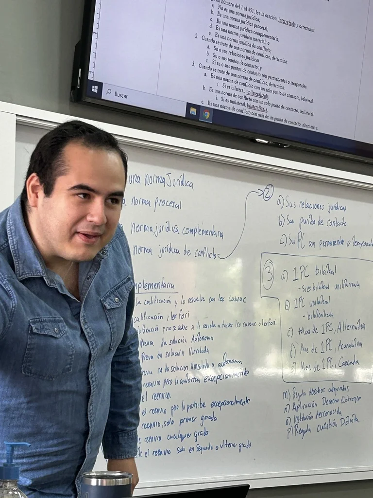 Estudiante de la FLDM explica un tema de derecho frente al pizarrón durante una clase